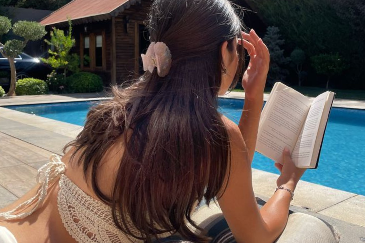 Your Glow Girl Guide to July - woman reading by pool
