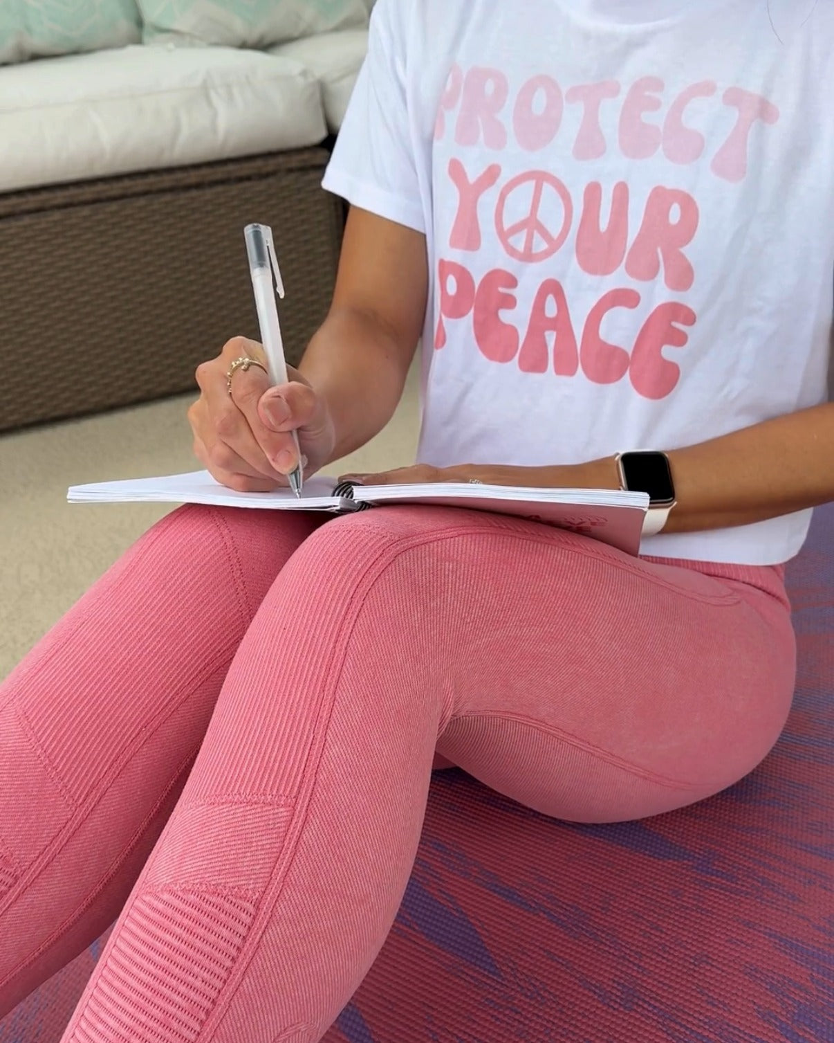 Stepha journaling on her yoga mat in a protect your peace tee - THE BEFORE chapter, About page